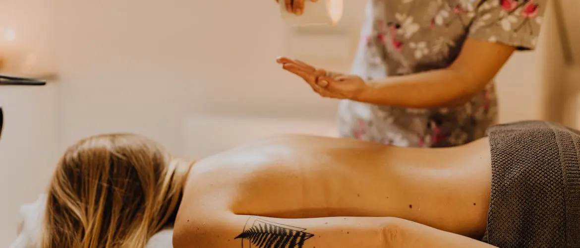 afbeelding van iemand die verwarmde massage olie krijgt