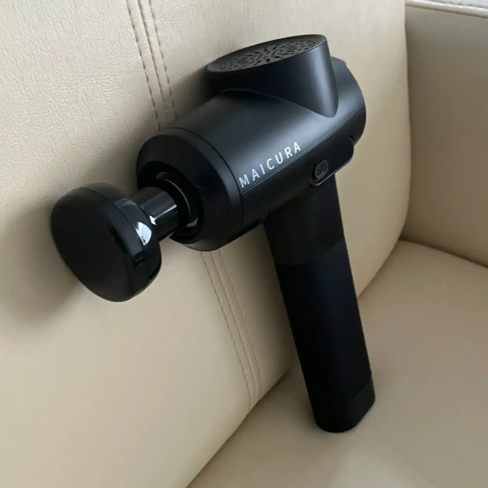 afbeelding van een massage gun met opzetstuk voor infrarood massage