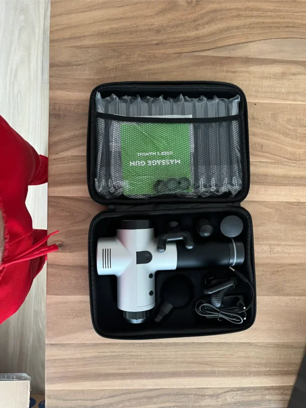 grijze Black Rhino massage gun met opzetstukken en adapter in de opbergkoffer