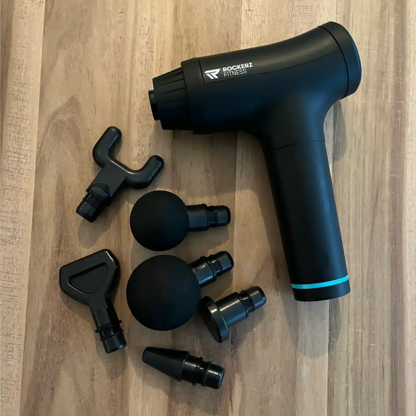 afbeelding van rockerz fitness massage gun met opzetstukken bij mij op tafel