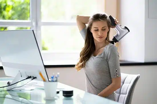 afbeelding van een vrouw die haar rug masseert met de hyundai massage gun