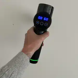 Fysio Pro massage gun in mijn hand met het display aan