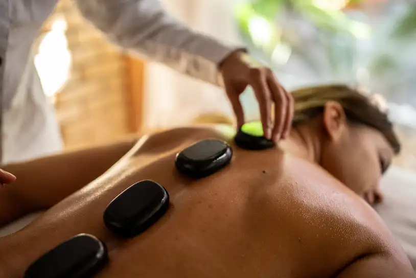 afbeelding van een vrouw die een hot stone massage krijgt